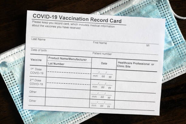 vaccine card with mask getty images