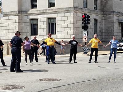 Protesters hold hands in traffic; police intervene