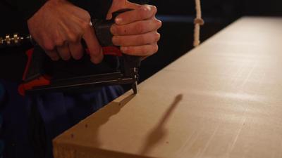 Man uses staple gun to construct something