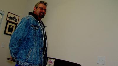 John Reese stands in his Helping Hands apartment