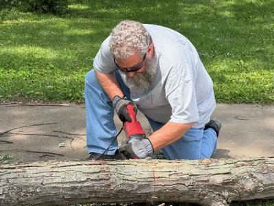 Karl Ziemer cuts up tree limb