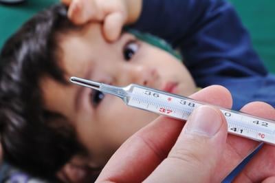 Sick little boy with thermometer in mouth