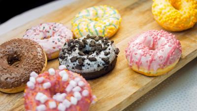 chocolate-marshmello-and-candy-donuts-on-a-retro-baking-tray-donuts-are-on-a-paper-dec-SBI-349530344.jpg