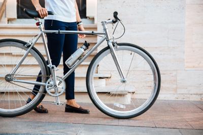 Cropped image of a female biker standing with bicycle