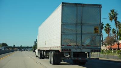 unbranded-white-semi-truck-driving-on-road-transporting-goods-on-sunny-day-SBI-349958212.jpg