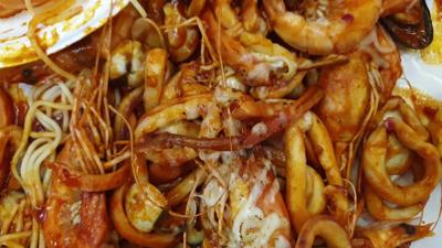 hand-picking-shrimp-bucket-cajun-bbq-poured-on-table-top-eating-party-seafood-steamed--SBI-350526701.jpg