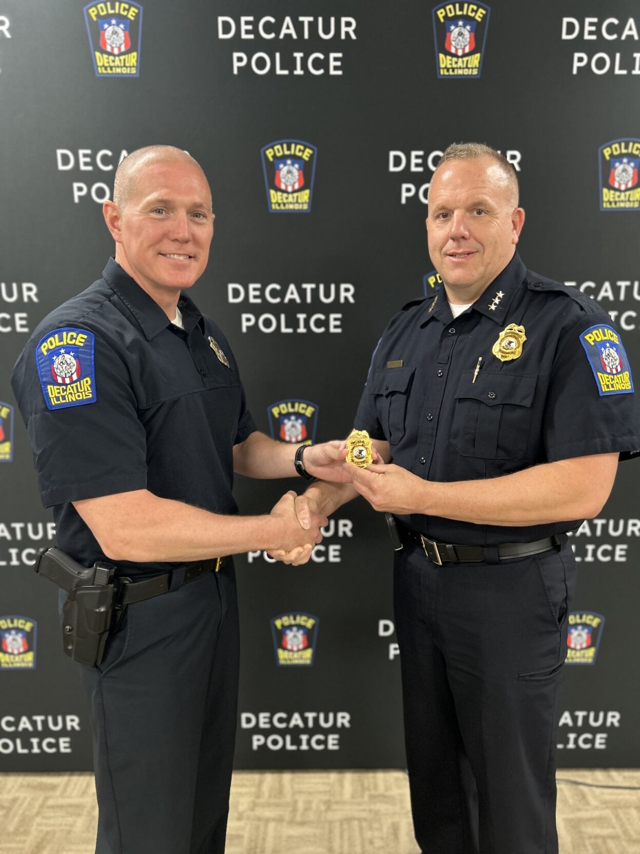 Retiring DPD Chief Shane Brandel presents chief badge to new Chief Brad Allen.