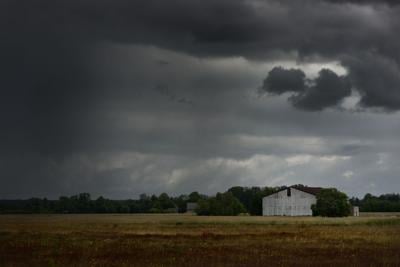 Tornado storm clouds above the shed in the countryside