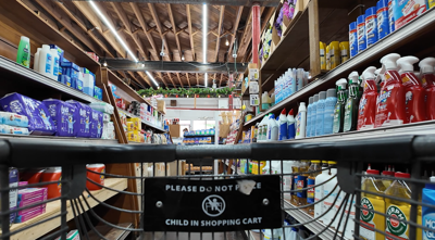A grocery shopping cart rolling down the aisle of a small grocery store in Cambridge.