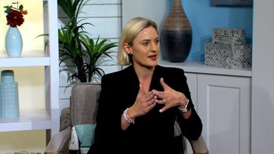 Madeleine Overturf sitting on the DelmarvaLife set wearing a black suit