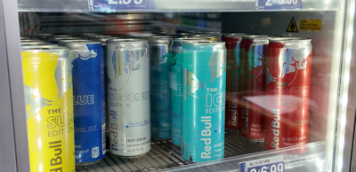 Red Bull energy drinks on shelf in gas station.