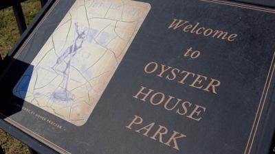 Sign that reads "Welcome to OYSTER HOUSE PARK", with drawing to the left of the text. 