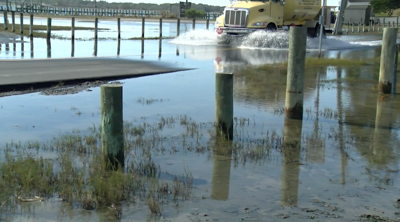 A truck drives through a flooded street near Oak Orchard, DE.