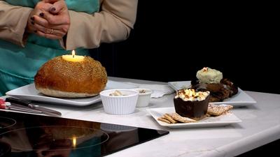 Butter Candle sitting in the top of sour dough bread plated on a white plate
small black bowl with roasted marshmallows sitting around a butter candle plated on white plate and a brownie plated on white plate with butter candle on top