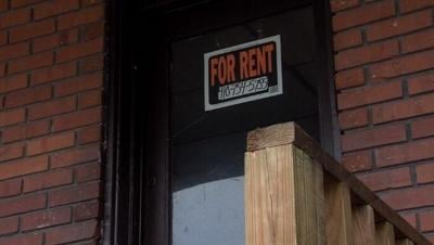 A picture of a glass door with a sign on it. The sign says "For Rent 410-754-5755"