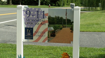 A sign commemorating 9-11 reading "9-11 Open Memorial to All / Never Forget"