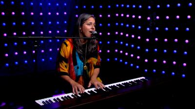 women with long dark hair performing on MSA stage playing the keyboard, singing. 