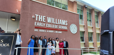 The Williams family and Early College School leaders standing below the new signage.