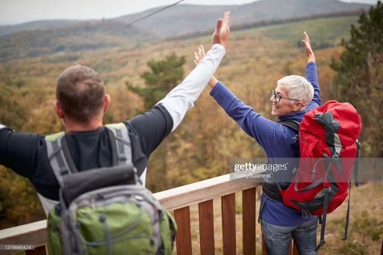 Senior couple trekking in the woods; Active retirment concept