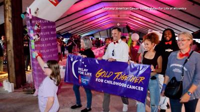 Group of Relay for Life participants holding a purple banner