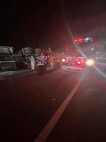 An 18-wheeler lies on its side at the intersection of MD 392 (Harrison Ferry Road) and North Tara Road as hazmat crews clean up a fuel spill. 