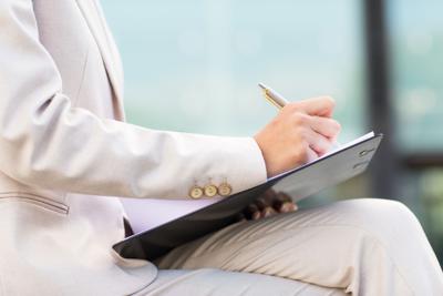 close up of business woman writing to clipboard