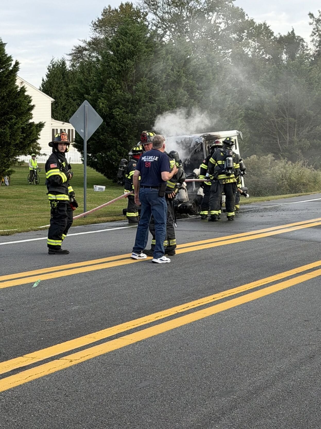 USPS truck smoking as firefighters put out the fire in Millville