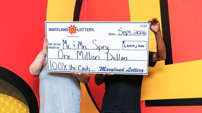 "Mr. and Mrs. Spry" holding up a giant check for one million dollars.