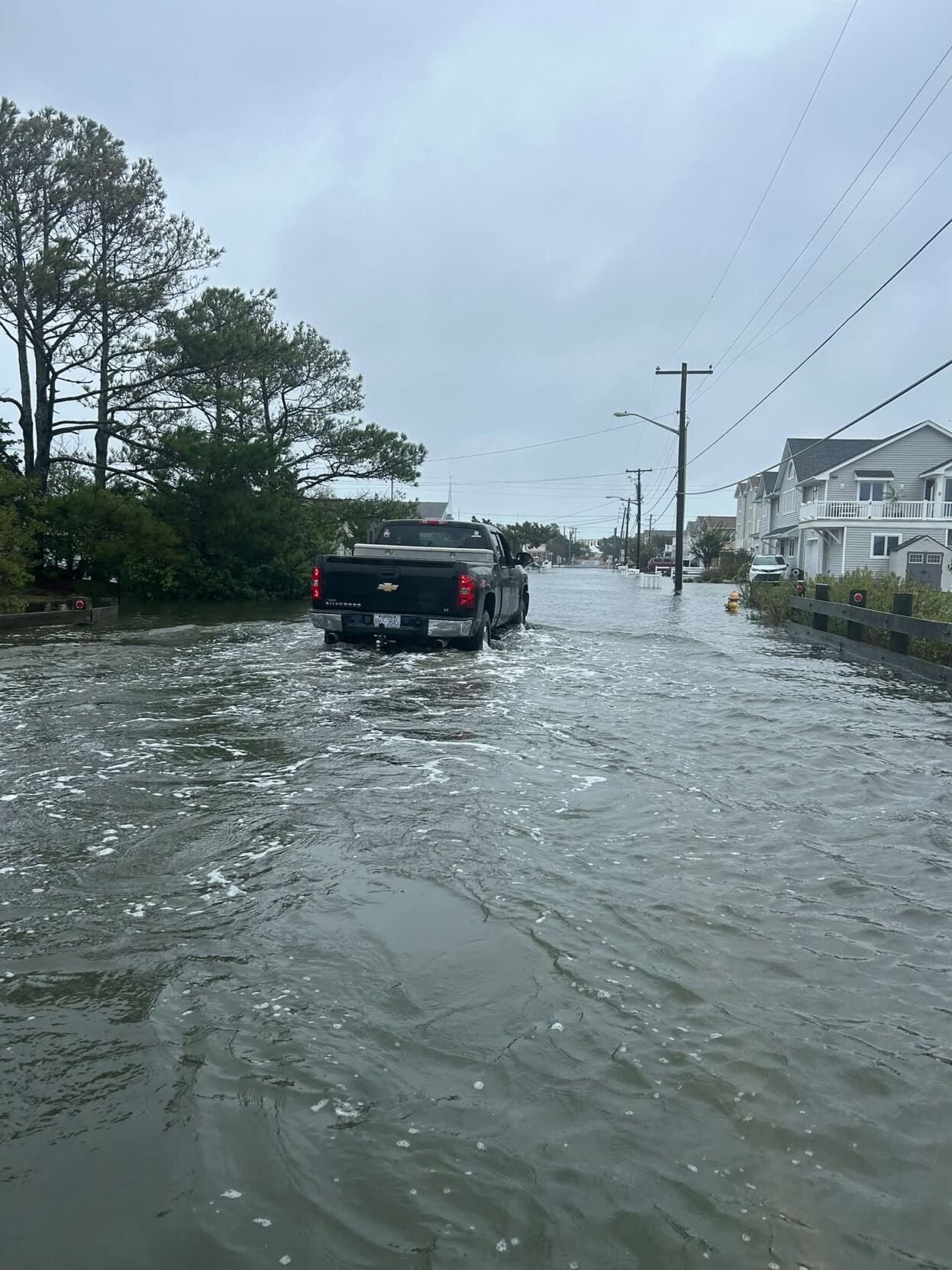 Truck driving through high floodwaters on Fenwick Island.