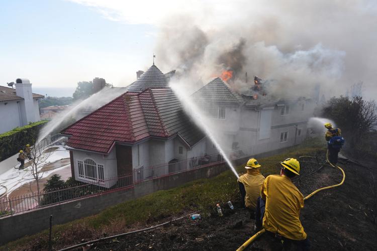Photos show wildfire fueled by high winds engulfing coastal homes in Southern California