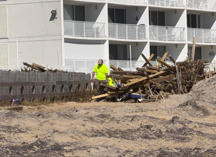 Public Works crews work to remove debris, included mangled fencing and lumber, from the sand in Ocean City. 