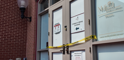 Doors closed off with caution tape, with signs directing visitors to the alternate entrances.