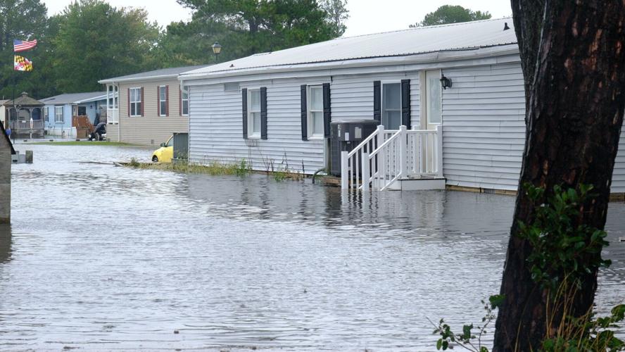A manufactured home surrounded by water. The water goes up to the top step on the entrance porch.