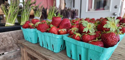 Fresh strawberries and asparagus at a local produce market.