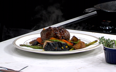 Steak dish with asparagus & carrot veggies plated on a with plate 