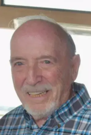 Man with white mustache and short white beard with blue plaid shirt 
