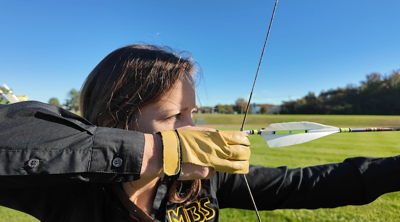 Maribeth Kulynycz, president of the Maryland Bowhunters Society, pulling back her bow. (WBOC).