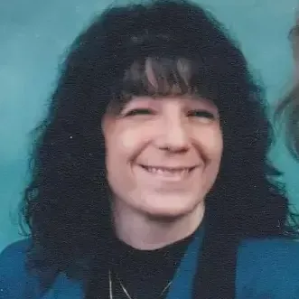 woman, black shoulder length hair., wearing black mock top covered with teal vest with aqua back ground