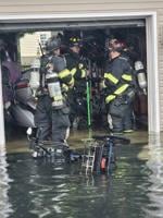 Three IRVFC members responding to garage fire in Nor'easter, floodwaters above their boots in the garage.