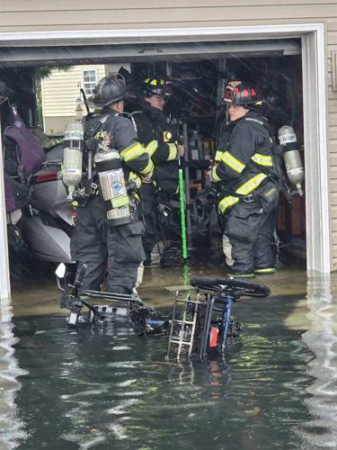 Three IRVFC members responding to garage fire in Nor'easter, floodwaters above their boots in the garage.