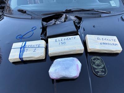 Four packages of suspected cocaine wrapped in plastic sitting atop the hood of a car.