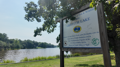 A picture of the Griffith Lake Boat Ramp sign with the lake behind it.