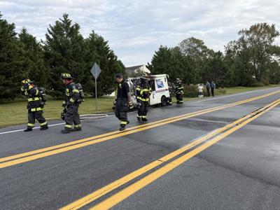 USPS truck smoking as firefighters put out the fire in Millville