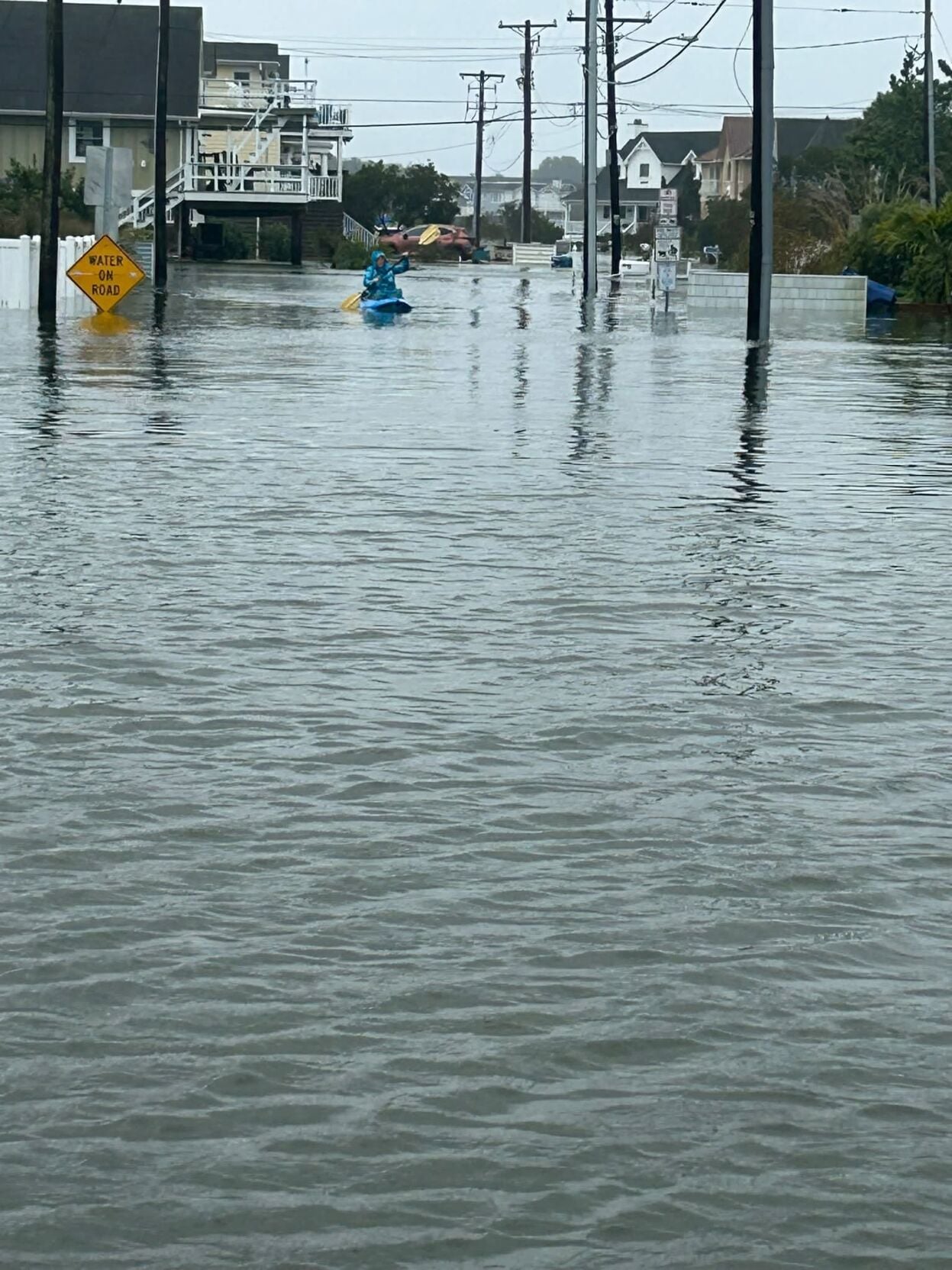 Kayaker in the high floodwaters on the streets of Fenwick Island.