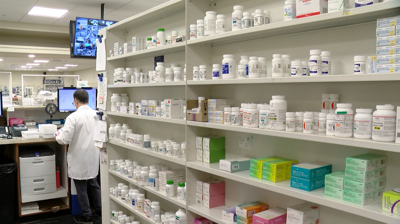 Pharmacy shelf stacked with medications.