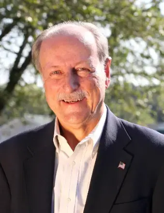 man with mustache in front of a tree