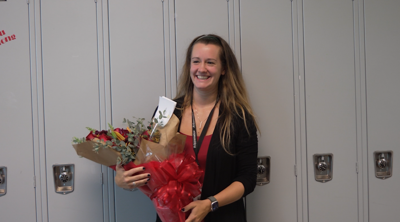 Dr. Chelsea Taylor of James M. Bennett High School holding a bouquet of flowers.