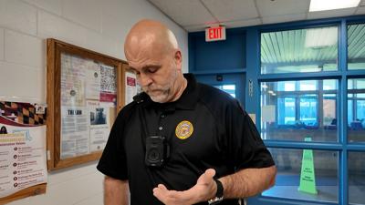The correctional officer demonstrates new body cameras.