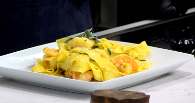 dish with yellow color egg noodles with shrimp, plated on a white plate