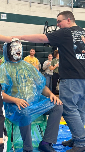 Odessa High School teacher Mike Husni is hit by a whipped cream pie during a 2024 "Pi Day" fundraiser